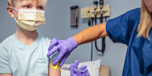 Image of clinician administering an injection with ShotBlocker to reduce pain.
